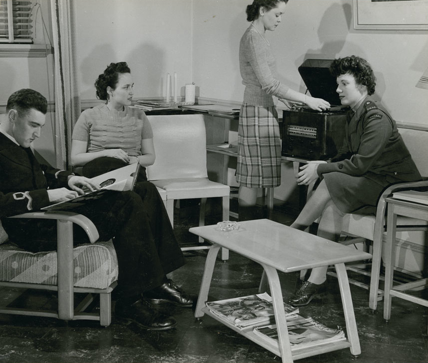 Four members of an organized listening group - three woman and one man - gather in the listening room at the London Ontario public library